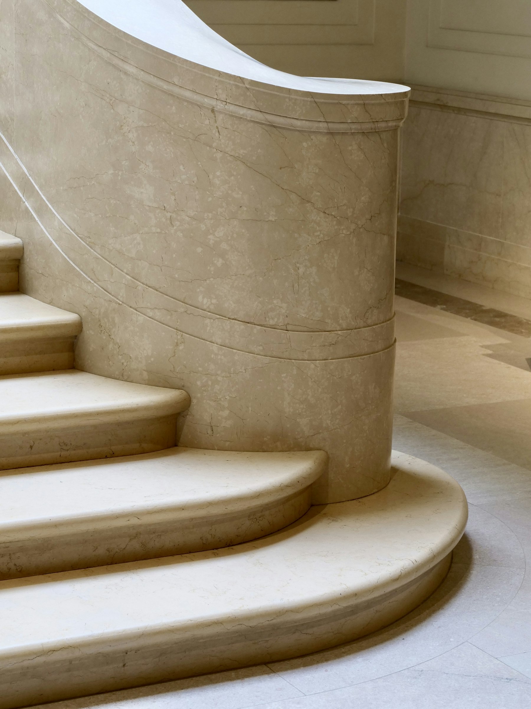 Book-matched stone staircase in a coastal residence